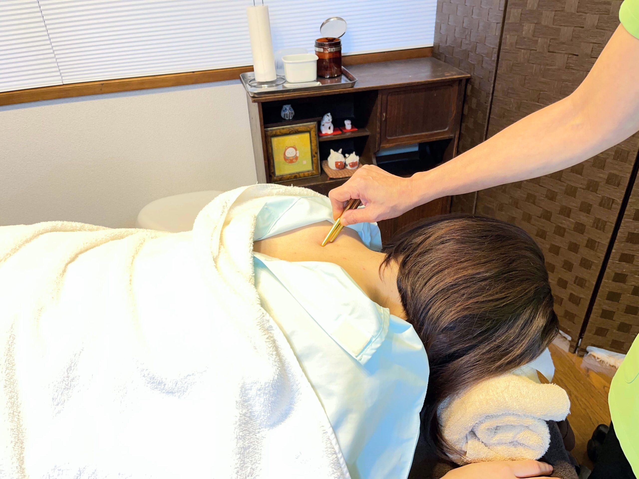 ごしんじょうをあおむけで受けている女性